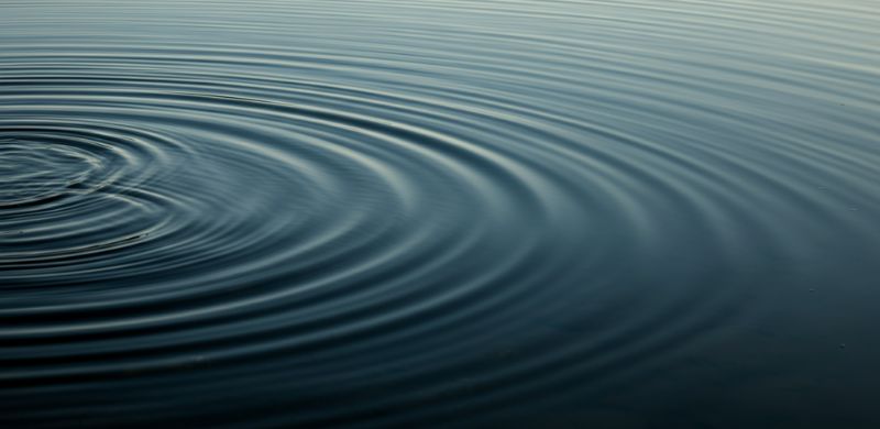 Ripples in calm water, symbolizing tranquility, mindfulness, and the ripple effect of inner peace.